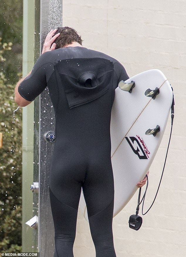 liam-hemsworth-shows-off-a-snug-wetsuit-as-he-emerges-from-the-surf-on-phillip-island-5