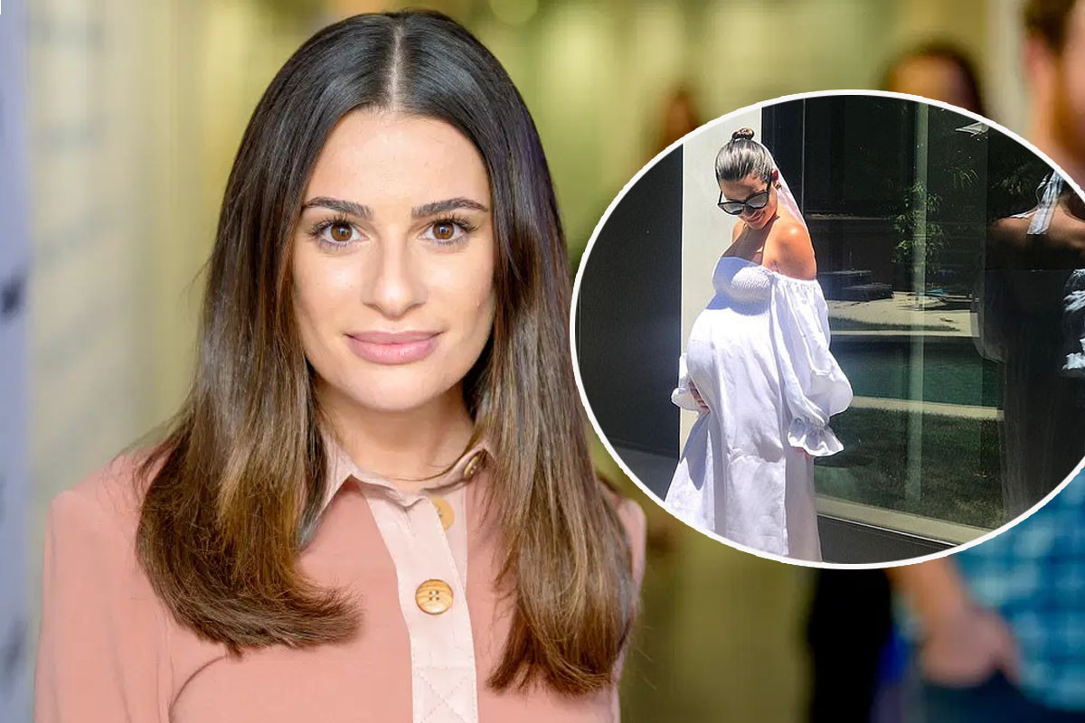 Pregnant Lea Michele cradles her baby bump wearing a white flowing dress